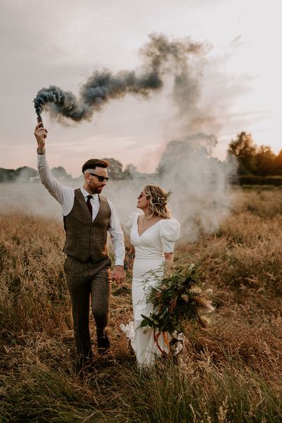 Willow Marsh Farm wedding with the bride and groom waving smoke bombs