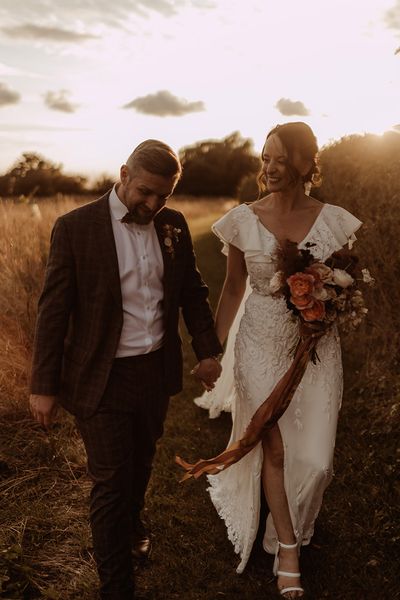 Bride in a bespoke Emma Beaumont Atelier wedding dresss with the groom in a grey suit.