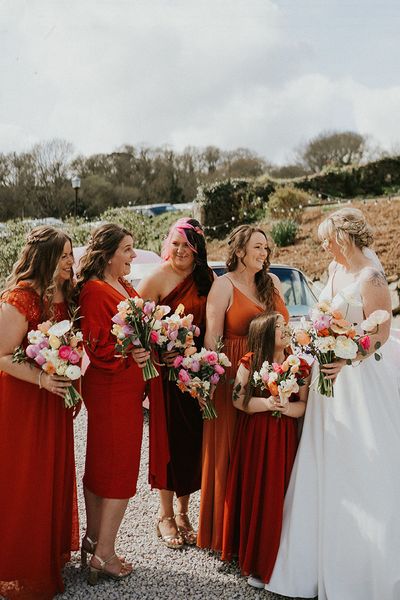 Tregedna Lodge wedding with bridesmaids in orange bridesmaid dresses.