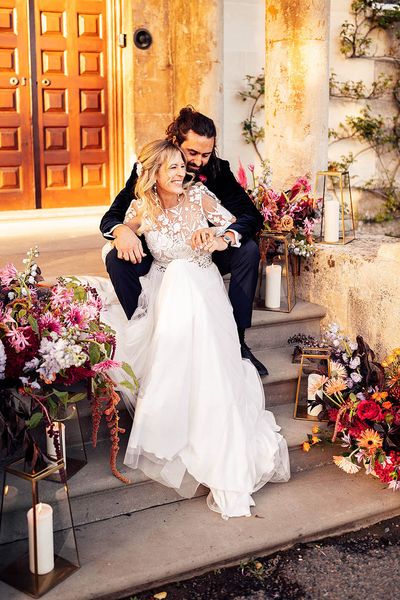 Bride in a Margaux Tardits wedding dress laughing with groom at their Elmore Court wedding.