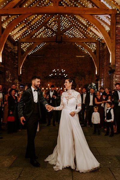 Bride and groom have their first dance with fairy-lights at rustic Hazel Gap Barn wedding venue. 