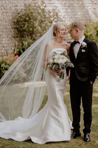 Bride and groom pose together for their Cissbury Barns black tie wedding.