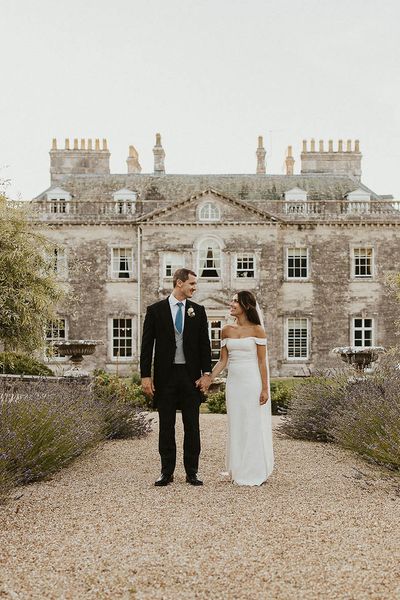 Bride and groom walking in front of Came House in Dorset.