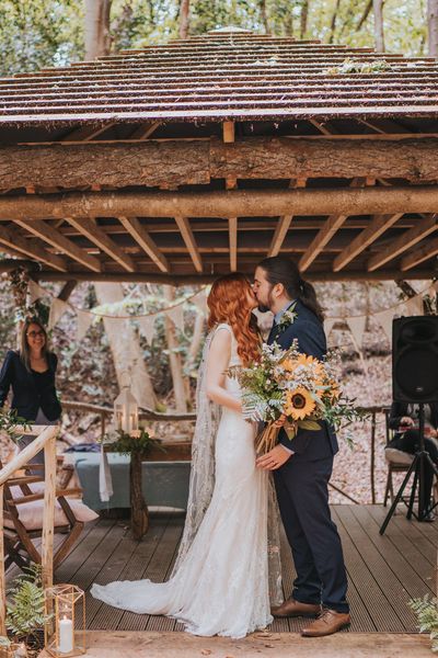 Outdoor forest wedding with sunflower wedding bouquet, embroidered veil and lace wedding dress.