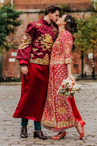 Bride and groom in traditional red and gold Chinese wedding attire for multicultural city wedding in Manchester