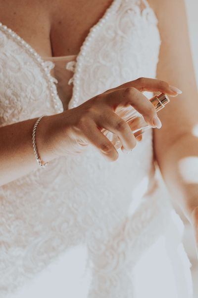 Bride Spraying Wedding Perfume on Wrist on Wedding Day 