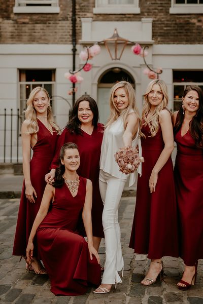 Bride with bridesmaids in dark red bridesmaid dresses for townhouse wedding.