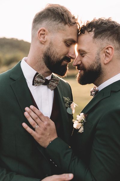 Grooms pose together in their dark green suits for their secular ceremony.