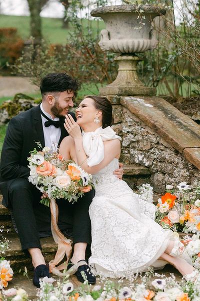 Romantic Holesfoot wedding inspiration with orange and white flowers, lace and beaded wedding dresses and an iced wedding cake