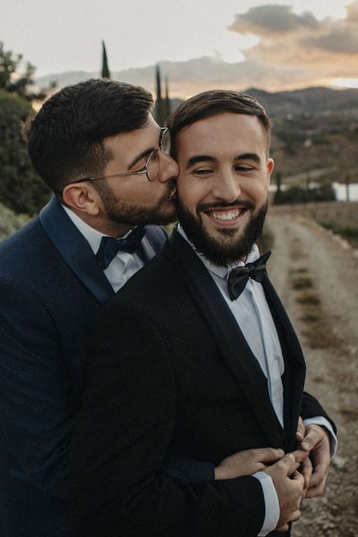 Hotel Cortijo Bravo Malaga wedding with two grooms In black and blue tuxedos, multicoloured pride mug favours and a Drag Queen act.