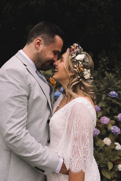 Bride wearing a wildflower wedding crown with groom at boho wedding.