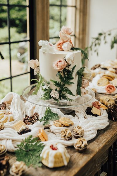 Vegan wedding inspiration with a dessert table and white iced wedding cake.