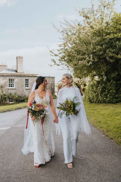 LGBTQI+ wedding with bride in handmade bridal jumpsuit with cape for five day long wedding adventure