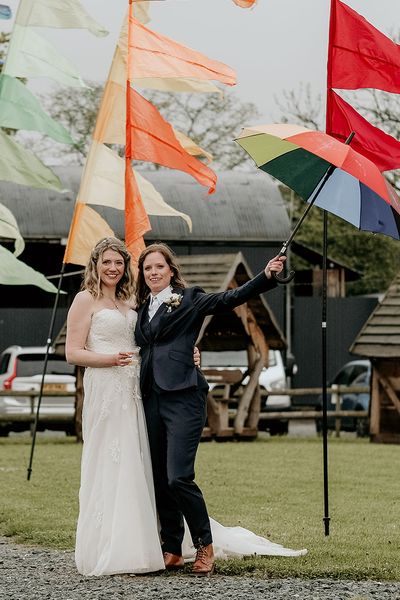 LGBTQIA+ Stanford Farm Pride wedding with rainbow festival flags, fairy lights and foliage weddng decor by The Bearded Man Photography