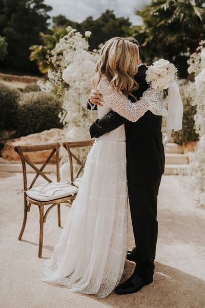 Intimate Pure House Ibiza wedding with white wedding flowers, wedding guests outfits & boho lace wedding dress by Balti Remeliai Photography