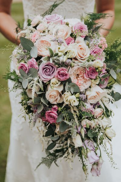 pink lilac and white bouquet filled with roses and lisianthus for bride wearing Christina Wu dress