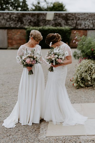 Lesbian couple at Woolas barn wedding with lace and embellished wedding dresses 