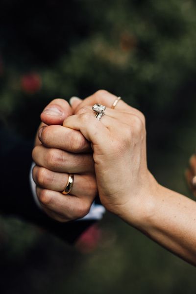 bride-and-groom-holding-hands-with-wedding-bands