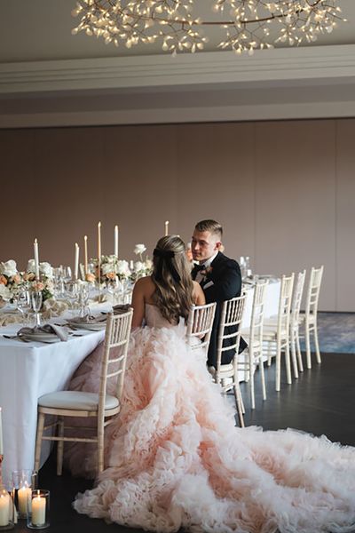 couple wearing peach tulle wedding dress and black groom tuxedo for formal wedding