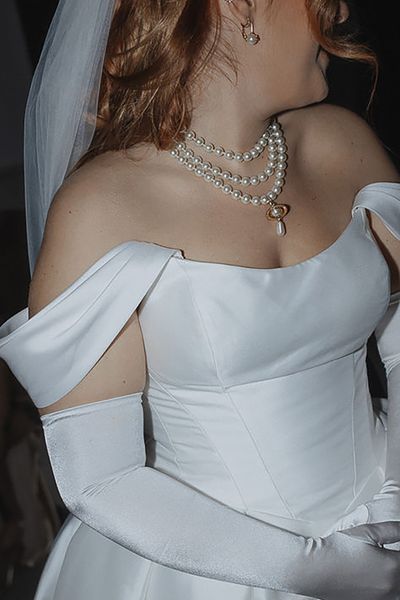 layered pearl wedding necklace, paired with an off-shoulder corset-style wedding dress