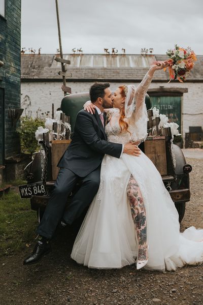 bride-and-groom-kiss-in-front-of-wedding-car-at-welsh-wedding