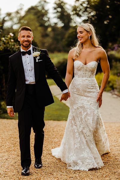 bride-wearing-lace-wedding-dress-with-groom-in-black-tuxedo-for-traditional-wedding