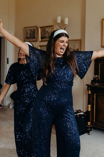 bridesmaids, wedding guests wearing glittery navy jumpsuits for weddings 