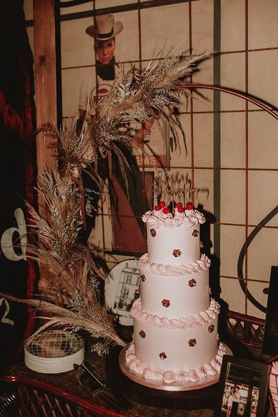 Light pink retro three tier wedding cake with cherries decorations to top