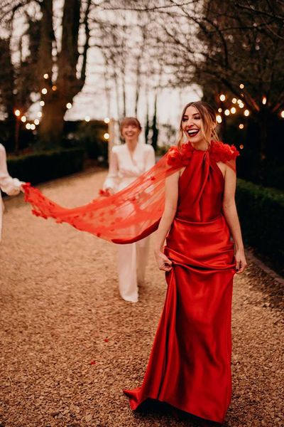 Bride in satin layered neckline red wedding dress with cape