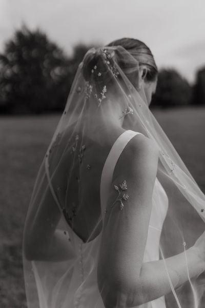 A black and white image of a bespoke wildflower embroidered wedding veil by Natasha Nicole Studio. Photography by Fiona Lewis