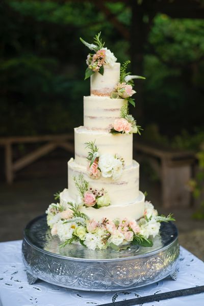 A 5-tier semi-naked wedding cake decorated with fresh flowers - Richard Greenly Photography