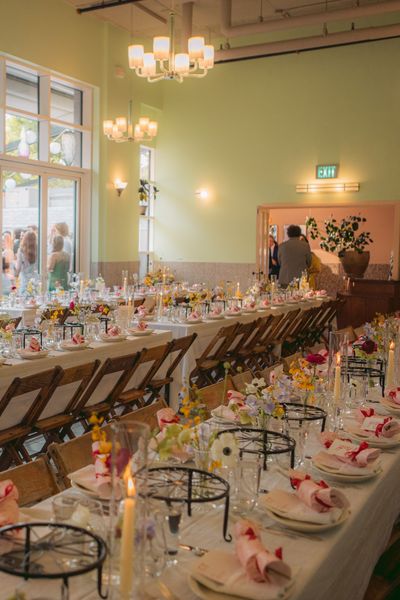 The interior dining room was built in a 1940/50 aesthetic. Simple Murano glass chandeliers and period sconces detail the terazzo tiled room.A full view of the outdoor patio garden abutts the dining room; in warm weather the accordion glass is left open and one large indoor / outdoor space offers versatile options for your celebration! Image credit: Kristen Nicolaisen.