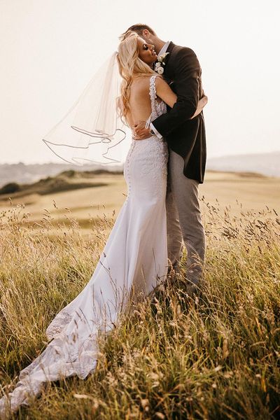 Elegant sunset shot of bride and groom in an editorial style.