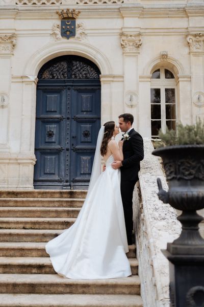 Georgina and Pete outside the front door of Chateau de la Valouze near Bordeaux, France. Georgina wore Elbeth Gillis, planners were Marry Me In France, Kate's Weddings France and PLH Weddings and Events. HMUA Anna Kotenji, florals Les Fleurs Couples, and catering Chez Amis Catering Dordogne.