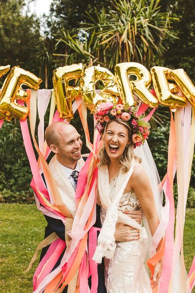 Pink and Peach Streamers, Gold Foil Balloons | Colourful Wedding Fiesta at Abbotsbury Wedding in Weymouth, Dorset | Decor from The Prop Factory | Bride in Made with Love | Photography by Paul Underhill.