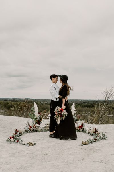 Black Wedding Dress for Wild Same-Sex Couple Wedding Inspiration | Pampas Grass, Eucalyptus & Red Rose Horseshoe Floral Design | Anne Letournel Photography