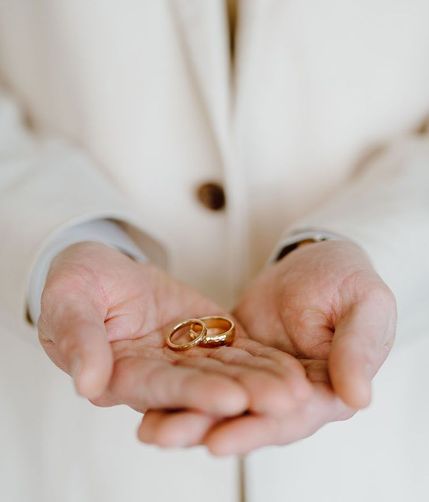 groom-holding-gold-engagement-rings