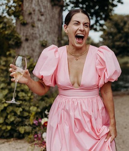 wedding guest in pink puff sleeve dress