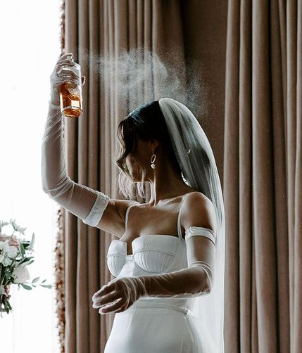 bride sprays wedding perfume