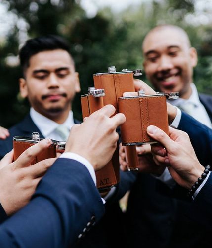 groomsmen holding matching flasks