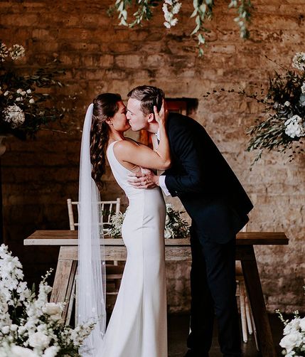 bride and groom sharing first kiss