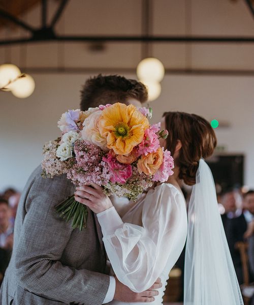 Colourful spring bouquet with orange giant poppy flower for festival theme wedding at Loft Studios. 