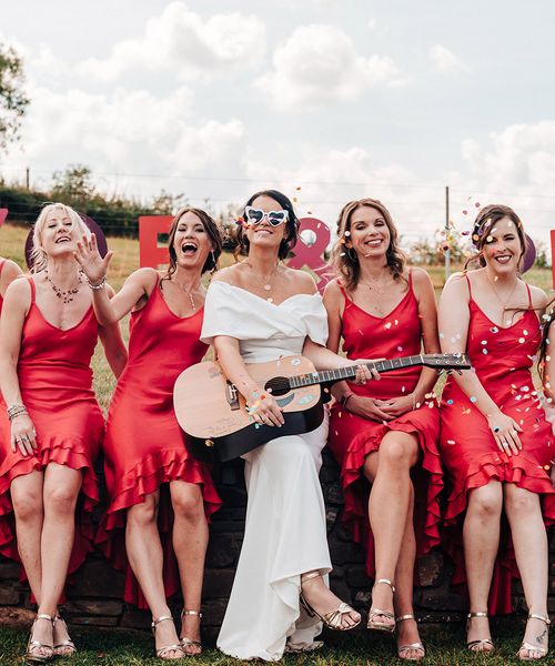 Bride in an ASOS wedding dress with bridesmaids in bright red dresses.