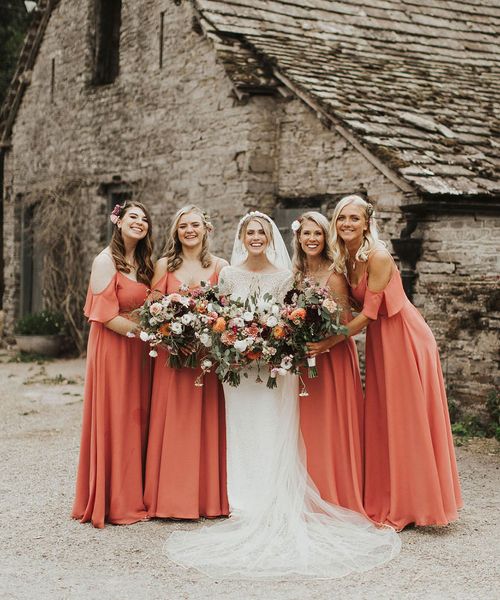 Bride with her bridesmaids in coral bridesmaid dresses from Rewritten Bridesmaids.