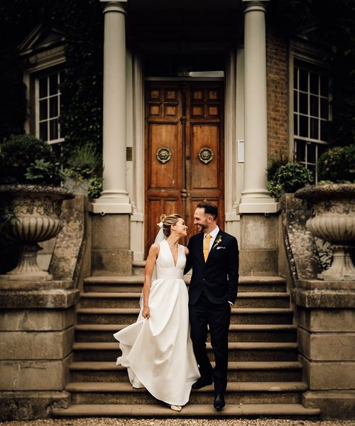 Hampton Court House wedding in Surrey with bride and groom posing together.