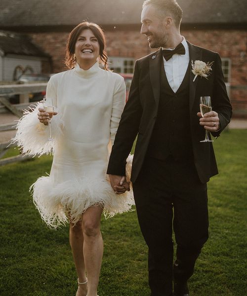 Larkspur Lodge wedding with bride wearing a short feather wedding dress with groom in black tuxedo