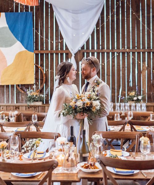 Bride and groom stand together at Deepdale Farm wedding venue for their DIY wedding,