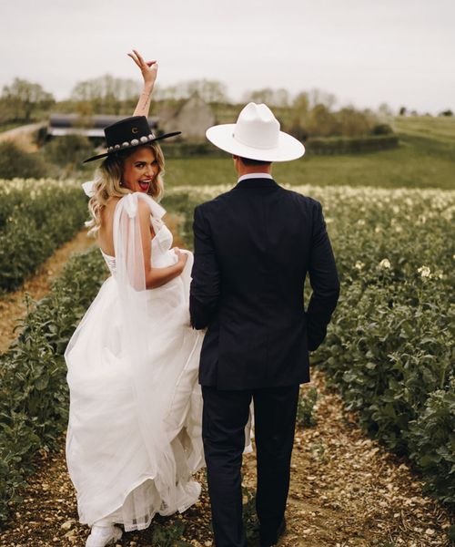 Country theme Stone Barn wedding with bride and groom wearing cowboy hats