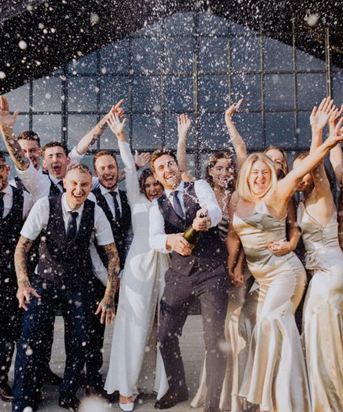 Wedding party pose for a champagne popping picture at The Barn at Botley Hill.