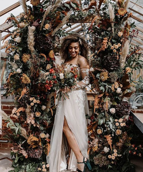 Bride surrounded by flower columns for a glasshouse reception.